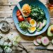 poached egg with vegetables and tomatoes on blue plate